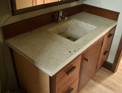 bath vanity with custom concrete counter and recycled redwood cabinet face